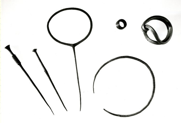 Middle Bronze Age ornaments from East Dean, Peadown hoard, Sussex. The middle pin is 30cm long. The object on the top right is a Sussex Loop bracelet. © Trustees of the British Museum